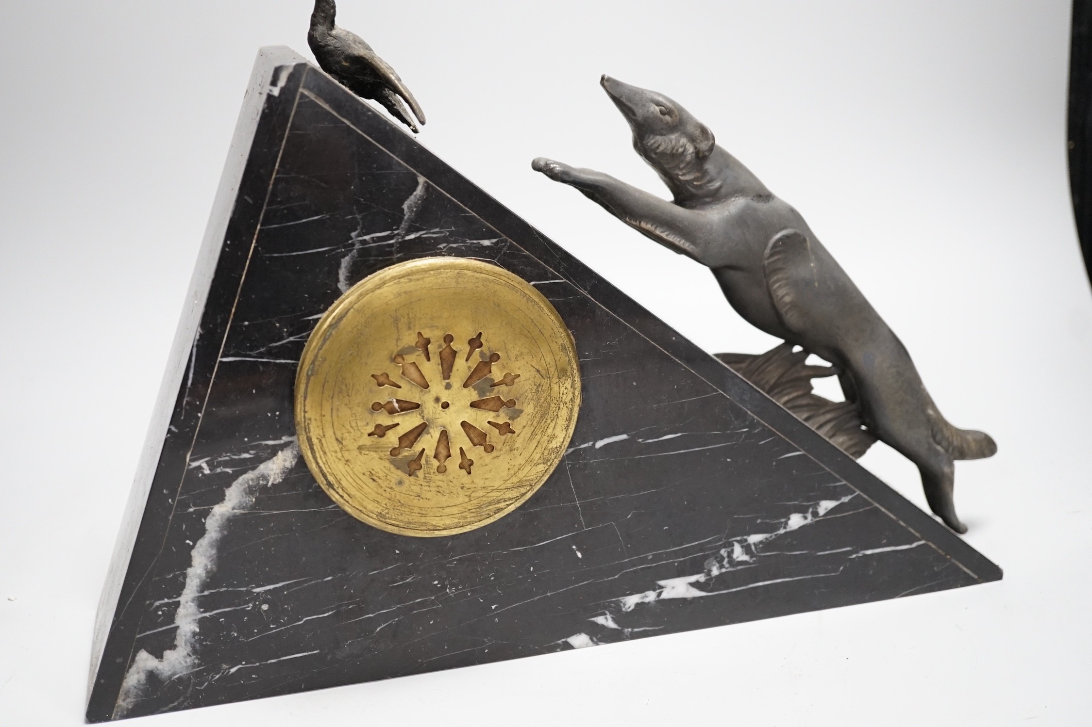 An Art Deco triangular marble and spelter clock, mounted with a fox chasing a bird, 39cms wide